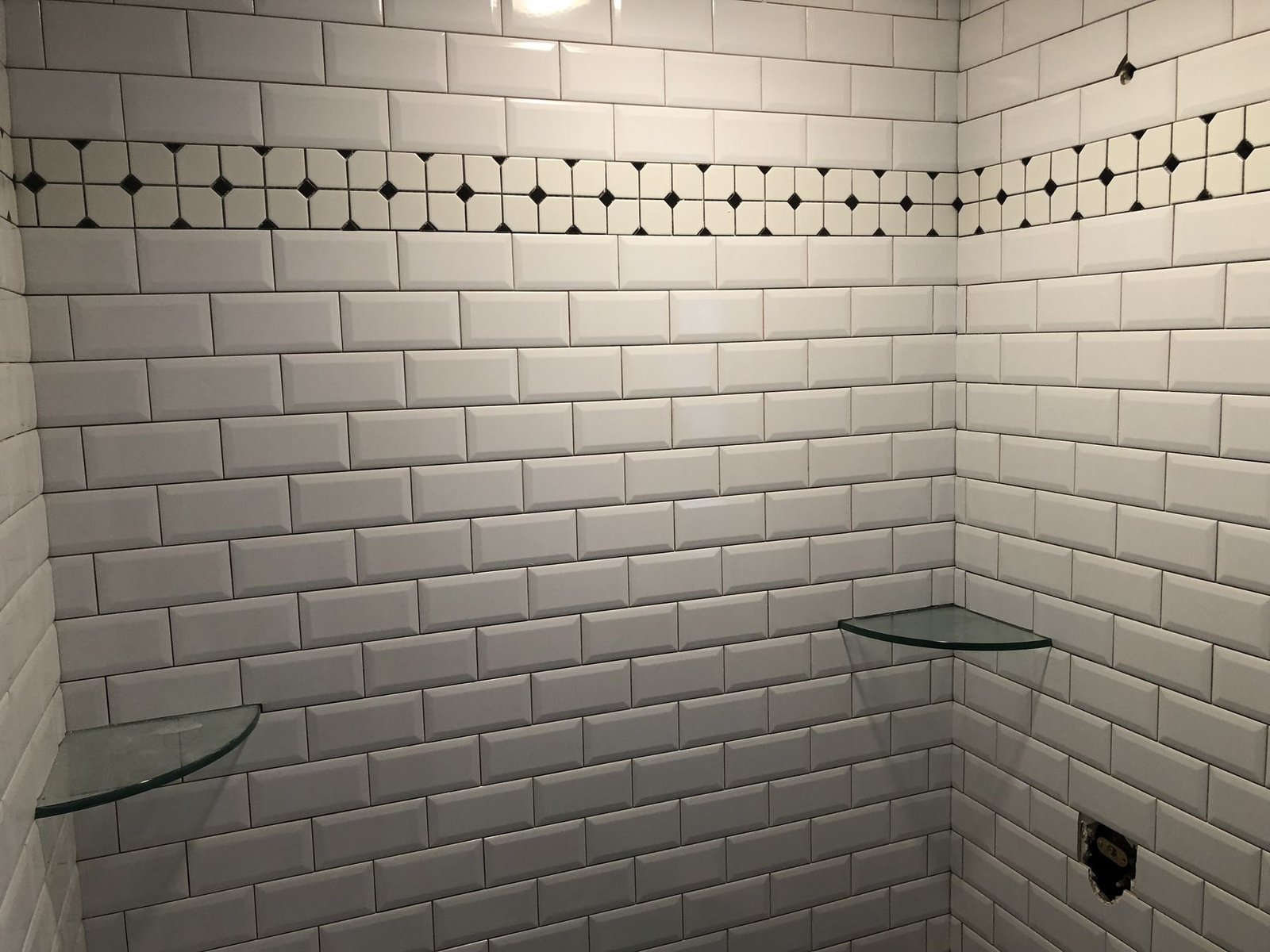 Tiled shower with glass corner shelves