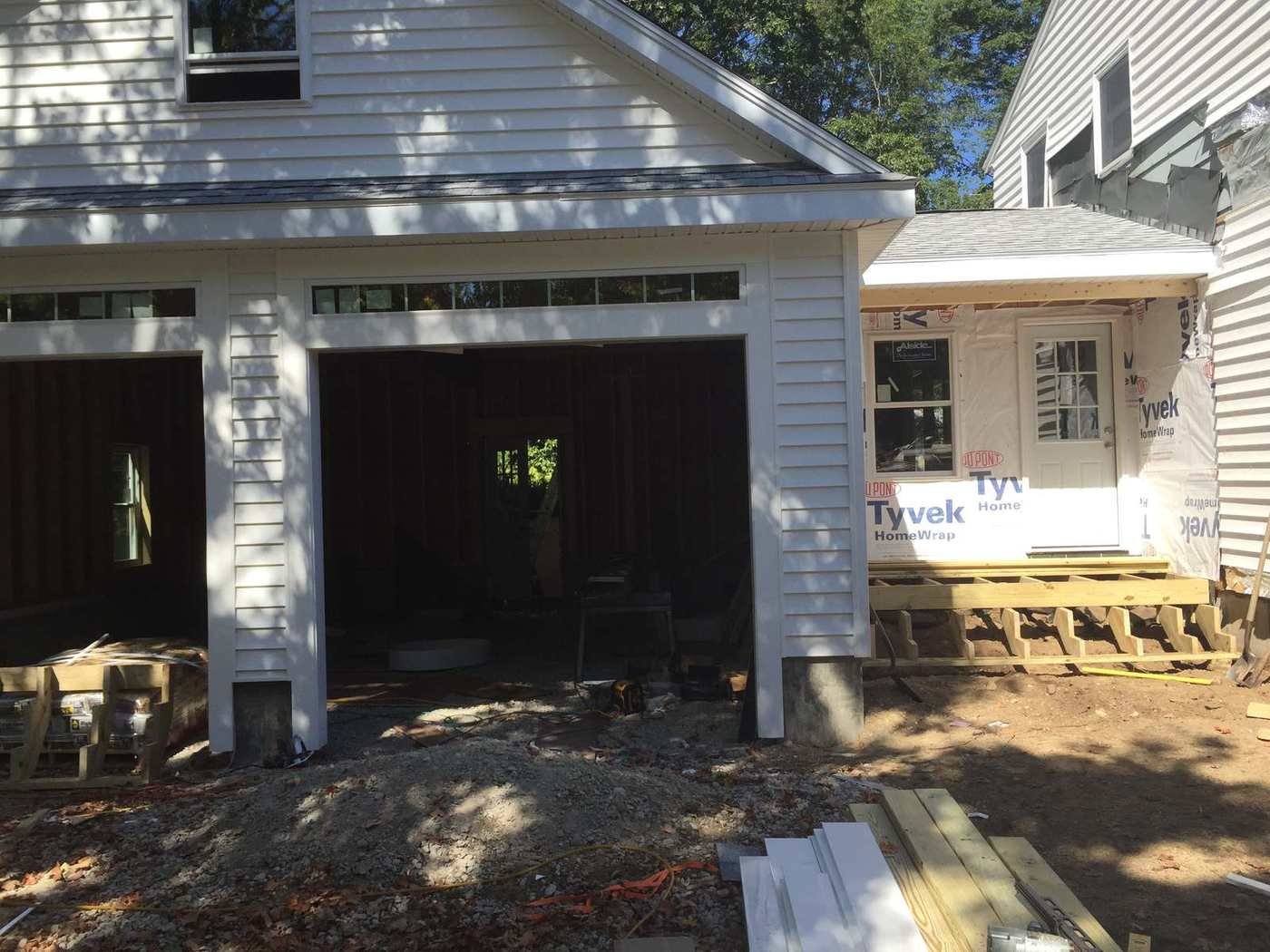 Both garage bay openings framed with house wrap on
