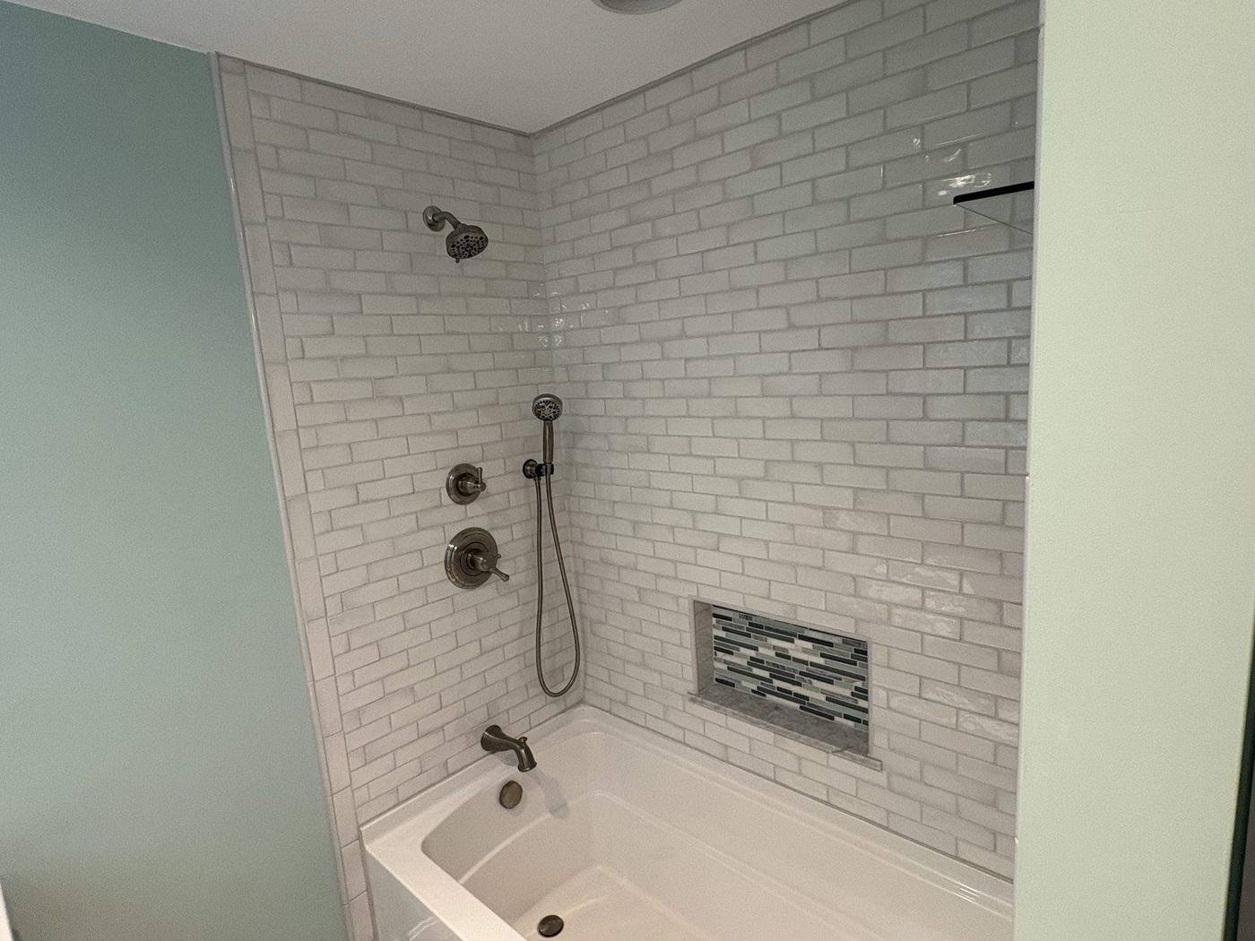 Subway tiled tub and shower with mosaic niche